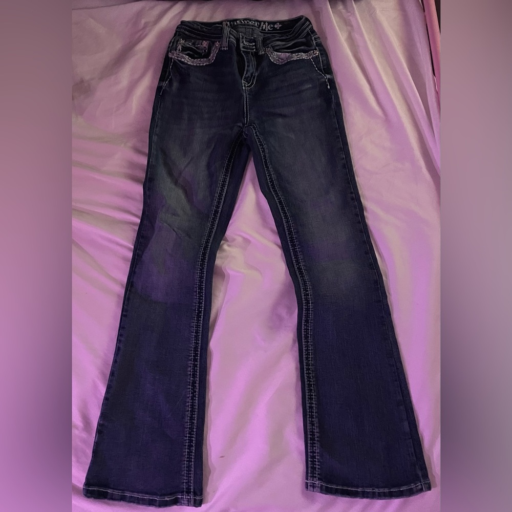 blue kind of flarred jeans with a design on the pocket